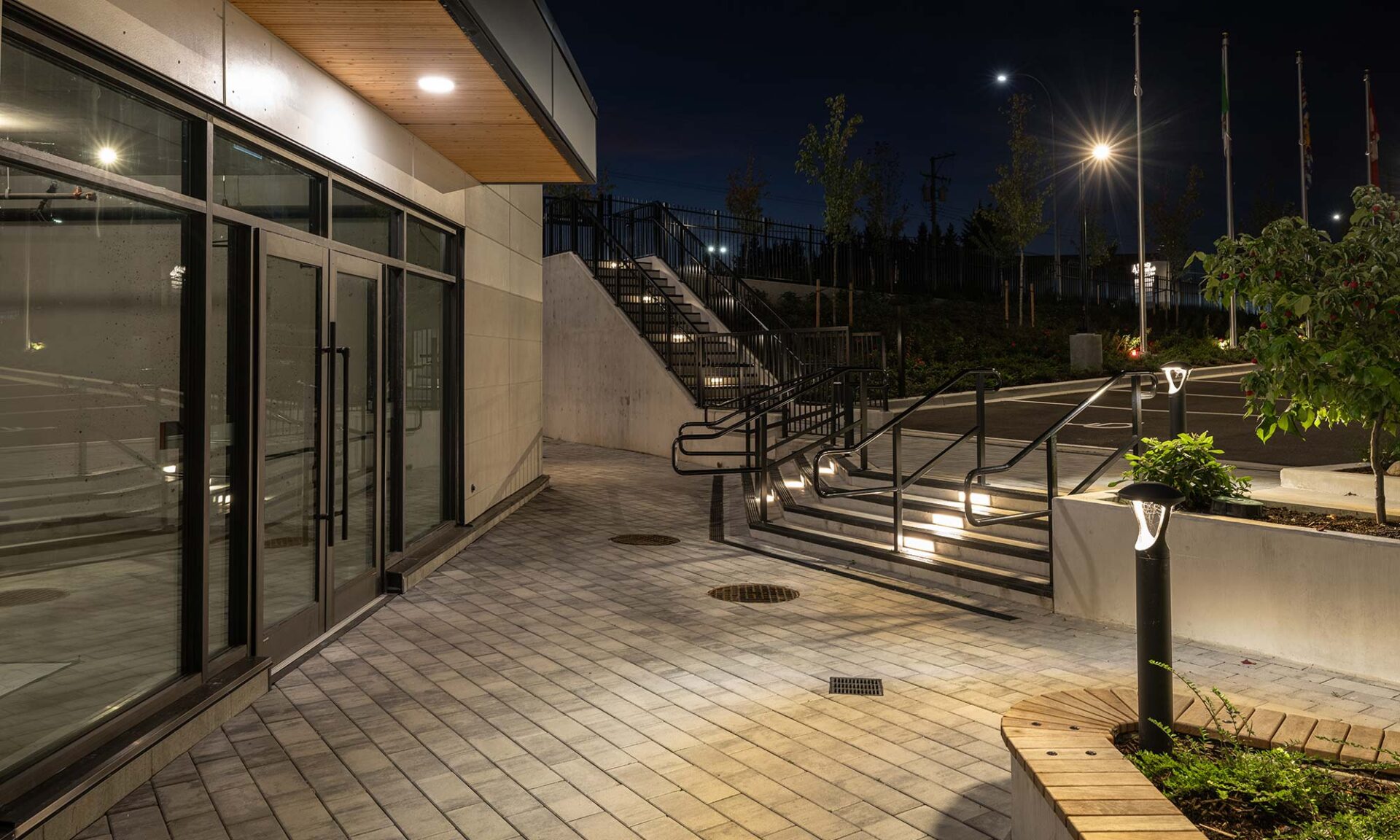 Evening exterior with timber soffit, HALO ultra-slim downlights, step and bollard lighting that highlight the architecture.