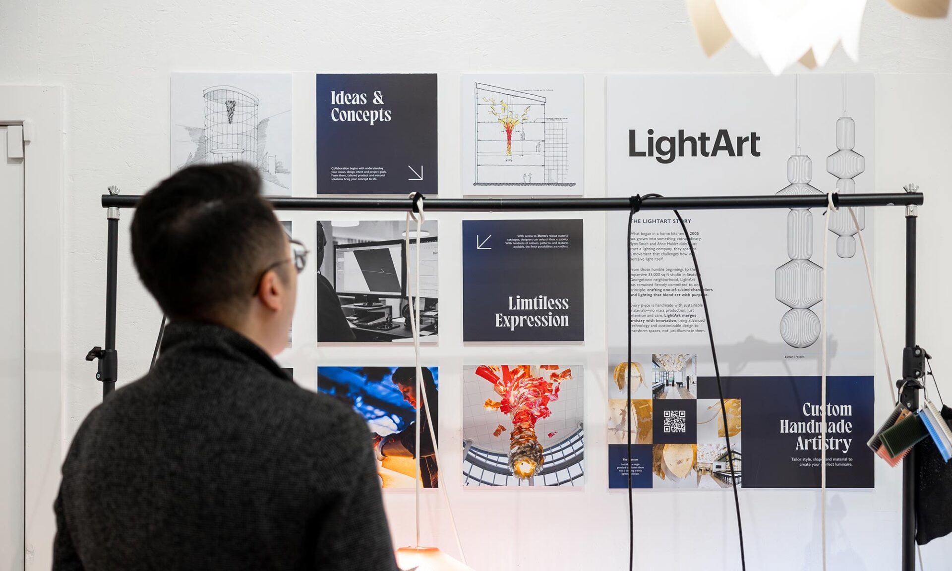 Guests exploring at Lumorphéa in Vancouver in front of a LightArt display case, with illuminated fixtures visible behind them during the Mac’s II Agencies exhibition.