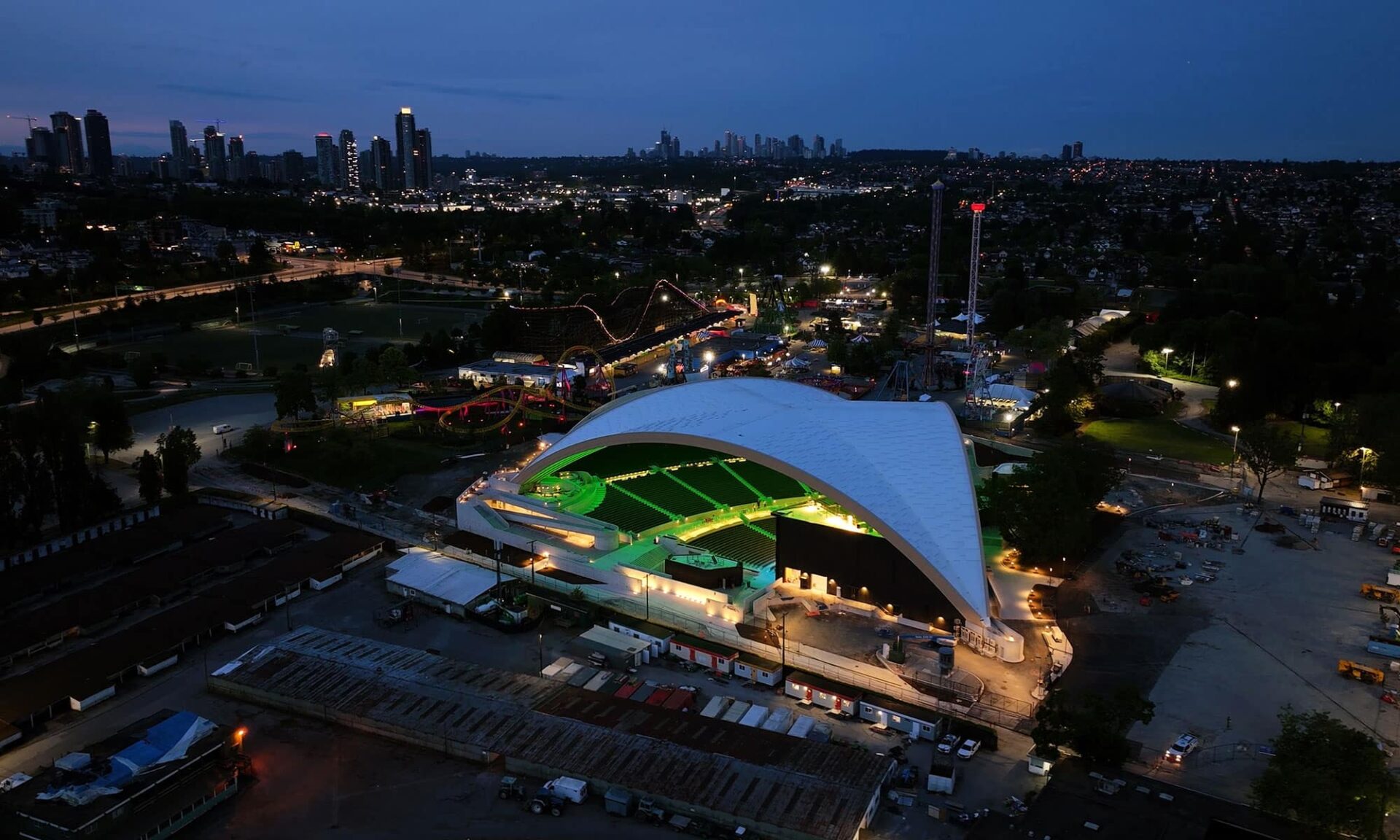 Wide nighttime exterior view of the PNE Amphitheatre Freedom Mobile Arch with integrated BL Lighting neonVIEW lighting running across the mass timber roof.