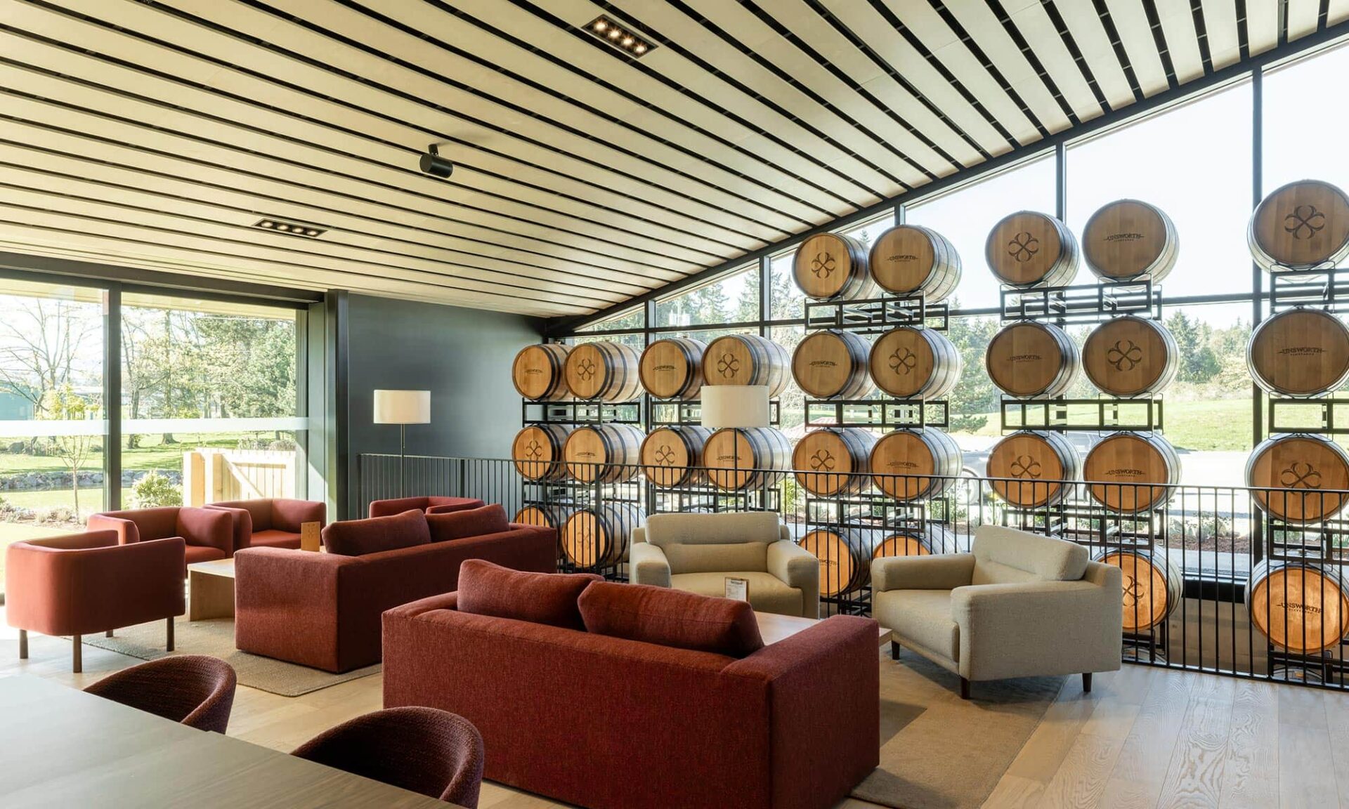 Barrel wall feature in the main tasting room at Unsworth Vineyards, shown in its completed setting with warm architectural lighting.